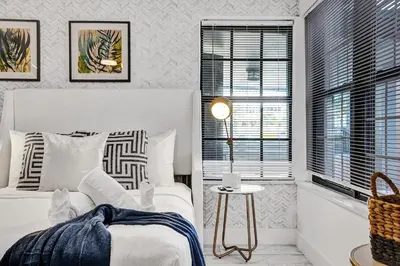 a white bedroom with a bed and a table at Hollywood Apartments Host by BeeNomad in Hollywood