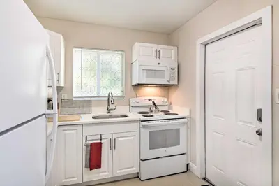 a kitchen with white appliances and a white door at Fort Lauderdale Apt Near Beaches and Shopping! in Fort Lauderdale