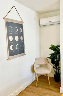 a chair in a room with a picture of the moon at Intimate Casita Mia minutes away from Airport, Calle 8, Brickell, Coral Gables, The beach and more! in Miami