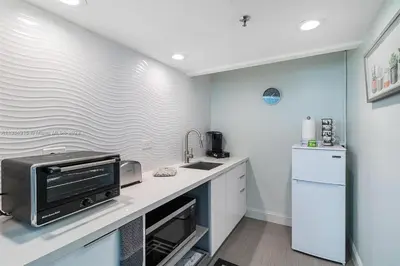 a kitchen with a counter with a microwave and a refrigerator at 11th Miami Beach - Ocean View -Free Valet Parking in Miami Beach