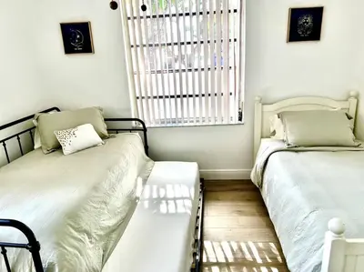 a room with two beds and a window and a window at Lush tropical big home close to Airport, Calle 8, Coral Gables and lots more Miami amenities in Miami