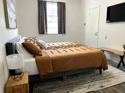 a bedroom with a bed and a television in it at Lush tropical big home close to Airport, Calle 8, Coral Gables and lots more Miami amenities in Miami