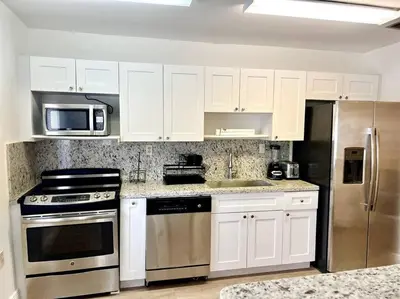 a kitchen with white cabinets and stainless steel appliances at Lush tropical big home close to Airport, Calle 8, Coral Gables and lots more Miami amenities in Miami