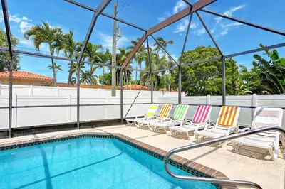 a pool with lounge chairs next to a swimming pool at Deluxe 5BR Villa Heated Pool near Hollywood Beach in Hollywood