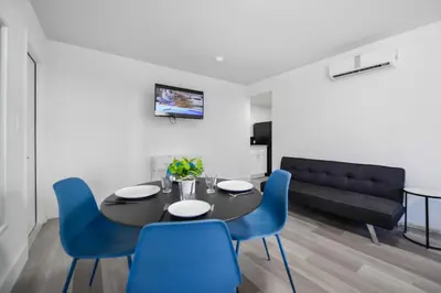 a dining room with a black table and blue chairs at Beachfront Getaway Studio with Parking - M21 in Hollywood