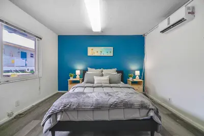 a bedroom with a blue accent wall and a bed at The mariner Suites #22 - Beachfront Studio in Hollywood