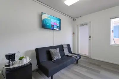 a living room with a blue couch and a flat screen tv at The mariner Suites #22 - Beachfront Studio in Hollywood