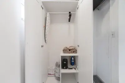 a white bathroom with white walls and a shelf at The mariner Suites #22 - Beachfront Studio in Hollywood