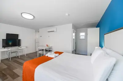 a bedroom with a large white bed and a tv at Hollywood Beach Retreat Studio - M23 in Hollywood