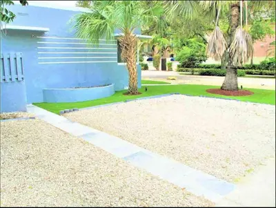 a house with a palm tree and a gravel driveway at Unique Las Olas Stay Pool Free Parking in Fort Lauderdale