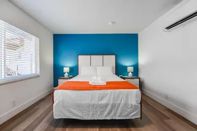 a bedroom with a large bed with a blue wall at Beachfront Studio with Pool access -M24 in Hollywood