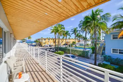 a balcony with white chairs and palm trees at Family Friendly Beach Escape with pool and parking - M41 in Hollywood