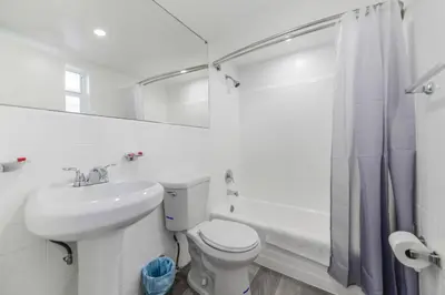 a white bathroom with a toilet and a sink at Peaceful Studio by the Beach with Parking - M25 in Hollywood