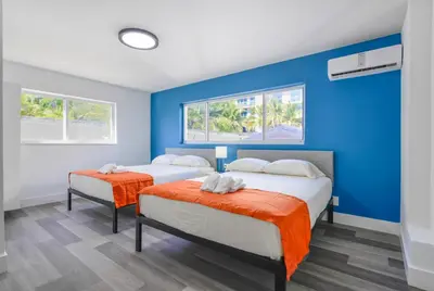 two beds in a room with blue walls and windows at Radiant Unit with parking and pool - M26 in Hollywood