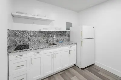 a white kitchen with a sink and a refrigerator at Radiant Unit with parking and pool - M26 in Hollywood