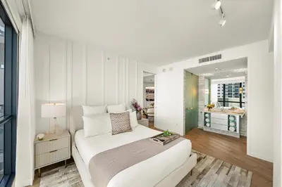 a white bedroom with a bed and a table at Private Residence at South Beach - 811 in Miami Beach