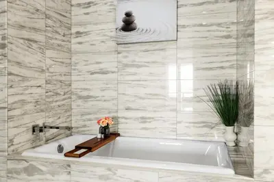 a white bath tub in a bathroom with marble tiles at Private Residence at South Beach - 811 in Miami Beach