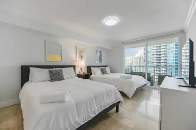 two beds in a bedroom with a view of a city at Centric 40thFloor Brickell Condo FREE parking by Palermo Home Miami in Miami