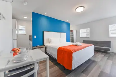 a bedroom with a large bed and a blue wall at Wonderful Studio with pool and parking at the beach! M31 in Hollywood