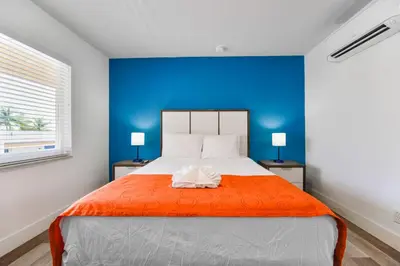 a bedroom with a large bed with a blue wall at Comfortable Beachfront Studio with pool! -M32 in Hollywood