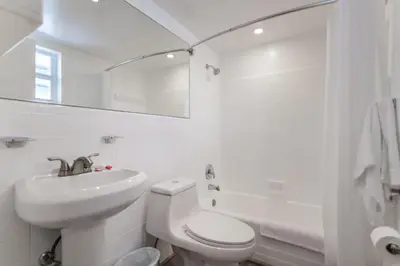 a white bathroom with a toilet and a sink at Comfortable Beachfront Studio with pool! -M32 in Hollywood