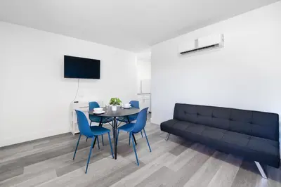 a dining room with a black couch and a table and chairs at Spacious unit with pool and parking - M33 in Hollywood