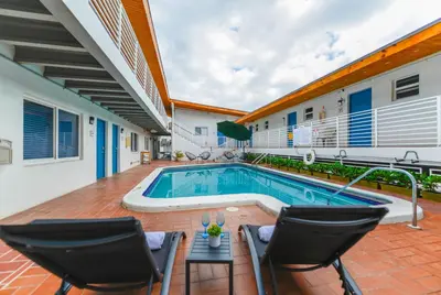 a swimming pool in a house with two chairs and a table at Magical Beach Escape with Pool -M37 in Hollywood