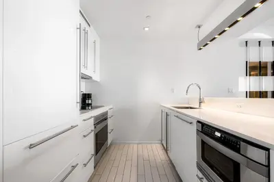 a white kitchen with white cabinets and a sink at Ocean View Residence at South Beach -1114 in Miami Beach