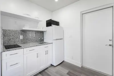 a white kitchen with white cabinets and a refrigerator at Ocean view Balcony with Pool & Parking -M42 in Hollywood