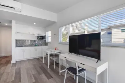 a kitchen with a white table and a large screen tv at Spacious studio with Balcony and Parking at the Beach -M46 in Hollywood