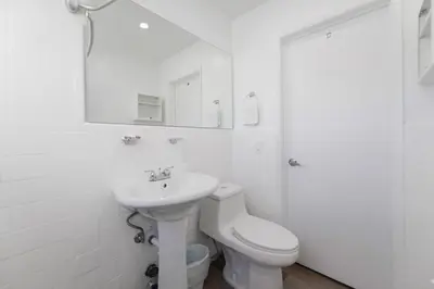 a white bathroom with a sink and a toilet at Spacious studio with Balcony and Parking at the Beach -M46 in Hollywood