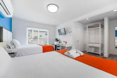 a bedroom with two beds and a television at Studio with Balcony and Parking - M47 in Hollywood