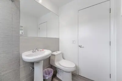 a white bathroom with a toilet and a sink at Studio with Balcony and Parking - M47 in Hollywood