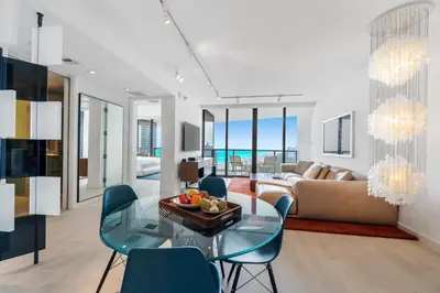a living room with a glass table and blue chairs at OceanView Private Residence at South Beach -1614 in Miami Beach