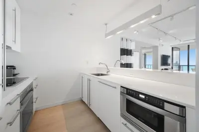 a white kitchen with a sink and a mirror at OceanView Private Residence at South Beach -1614 in Miami Beach