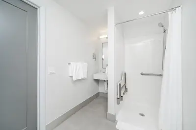 a white bathroom with a shower and a sink at The Julia Hotel in Miami Beach