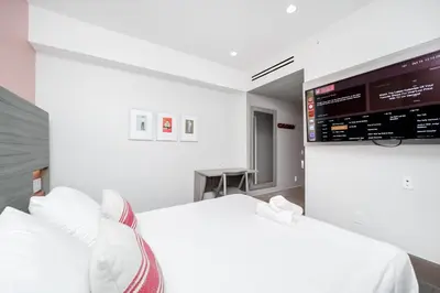 a bedroom with two beds and a flat screen tv at The Julia Hotel in Miami Beach
