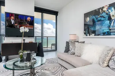 a living room with a couch and a tv at Stunning 3B Oceanfront at South Beach - 1229 in Miami Beach