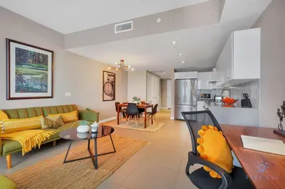 a living room with a yellow couch and a kitchen at Modern Miami Gem - City View Condo - Free Parking in Miami