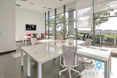 a dining room with white tables and chairs and large windows at Modern Miami Gem - City View Condo - Free Parking in Miami