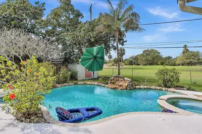 a swimming pool with an umbrella in a yard at Pool Heat I Firepit and BBQ I 75