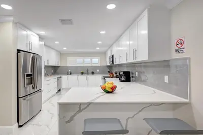 a white kitchen with a bowl of fruit on a counter at Deluxe 5BR & 3BA Villa in Hollywood Lakes near Beach in Hollywood