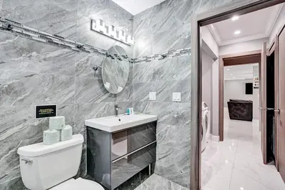 a bathroom with a toilet and a sink and a mirror at Spectacular 5BR & 5BA Villa in Hollywood Lakes in Hollywood