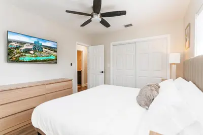 a bedroom with a white bed and a ceiling fan at Luxury 5BR Villa Heated Pool near Beach & Casino in Dania Beach