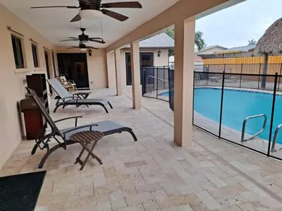 a patio with two chairs and a swimming pool at Pool home in Miami in Tamiami