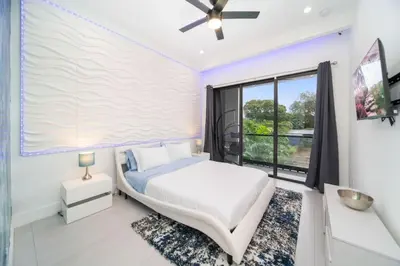 a bedroom with a bed and a large window at The Elements Luxury Home Fort Lauderdale in Fort Lauderdale