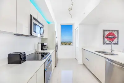 a white kitchen with a sink and a microwave at Beachwalk Resort - Waterfront huge 3-Bedroom apartment with direct ocean-view! in Hallandale Beach