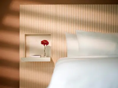 a bedroom with a vase with a red flower in a mirror at FOUND Hotels, Miami Beach, Series by Marriott in Miami Beach