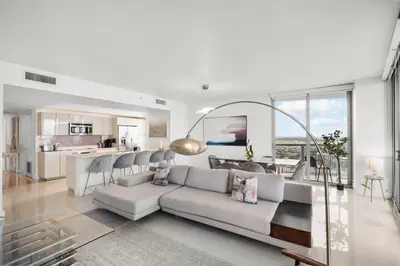 a living room with a couch and a kitchen at BeachWalk Resort - VIP TOWER - OCEANVIEW UNIT 3 BEDROOM & 3 BATHROOM in Hallandale Beach