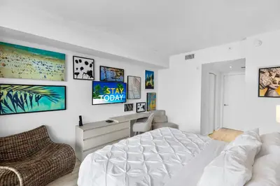 a white bedroom with a bed and some pictures on the wall at Hyde Resort Beachfront Condo #1904 - GORGEOUS 2BD & 2BA APT WITH OCEAN VIEW in Hollywood